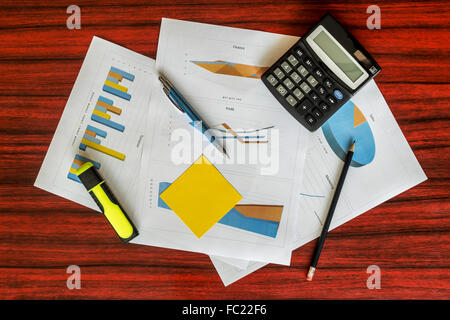 Groupe d'impression de graphiques avec calculatrice, trombones et un stylo sur eux Banque D'Images