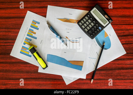 Groupe d'impression de graphiques avec calculatrice, trombones et un stylo sur eux Banque D'Images