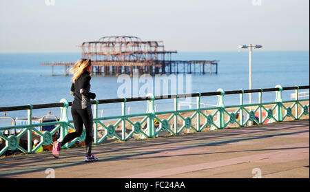 Brighton UK 20 Janvier 2016 - un coureur passe la jetée Ouest sur un beau matin ensoleillé mais froid sur le front de mer de Brighton . Le temps devrait rester ensoleillé et froid jusqu'à ce que le week-end quand le vent et la pluie devraient revenir à la Grande-Bretagne Crédit : Simon Dack/Alamy Live News Banque D'Images