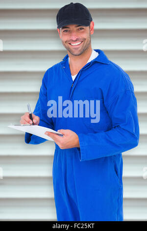 Image composite de handyman in blue dans l'ensemble writing on clipboard Banque D'Images