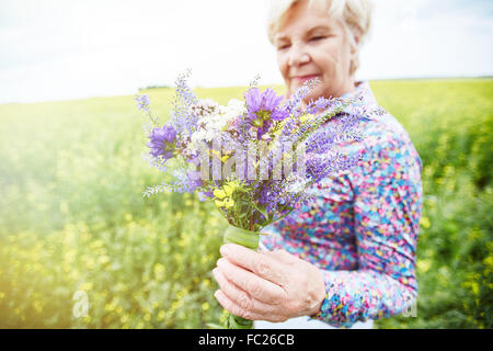 Senior female holding bouquet de fleurs sauvages Banque D'Images