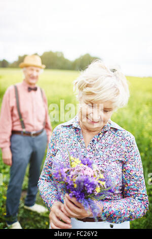 Mature Woman looking at bouquet de fleurs à l'extérieur Banque D'Images