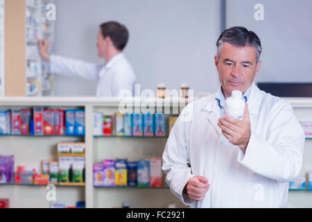 Concentrer votre pharmacien reading label on medicine jar Banque D'Images