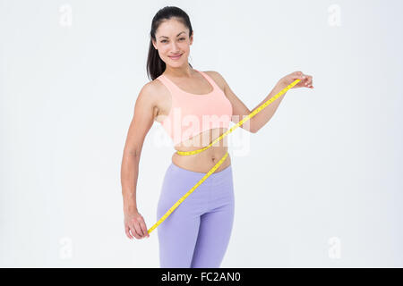 Smiling brunette holding measuring tape et looking at camera Banque D'Images