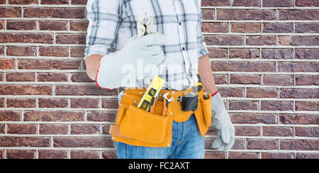 Image composite de technicien à ceinture d'outils autour de la taille une pince holding Banque D'Images