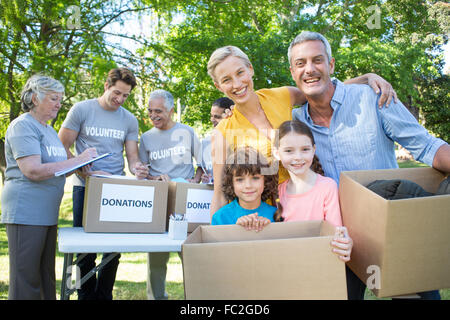 Happy Family holding boxes and smiling at the camera Banque D'Images