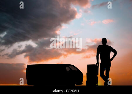 Composite image of delivery man leaning on trolley de boîtes Banque D'Images