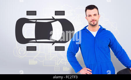 Portrait of male mechanic holding tire Banque D'Images