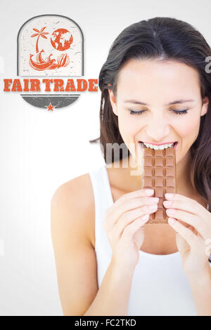 Image composite de jolie brunette eating barre de chocolat Banque D'Images