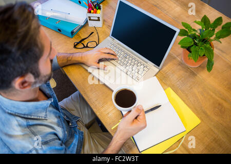 Businessman travaillant à son bureau et la tenue de tasse de café Banque D'Images