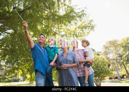 Famille heureuse à l'aide d'un bâton selfies dans le parc Banque D'Images