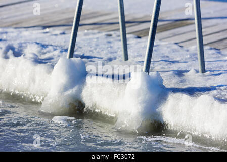 Une piscine ou baignade dock pier a gelé dans la glace de mer à l'hiver. Vu de la mer avec la terre en arrière-plan. H Banque D'Images