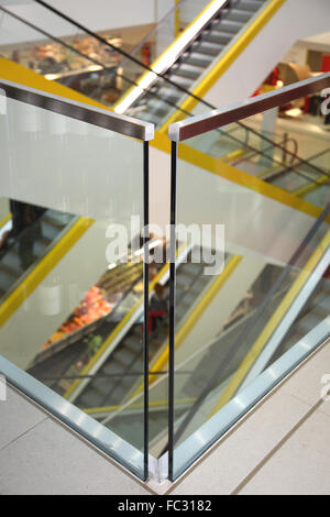 Close up d'acier et de verre balustrade dans un centre commercial moderne. Montre les escaliers mécaniques à l'arrière-plan. Banque D'Images