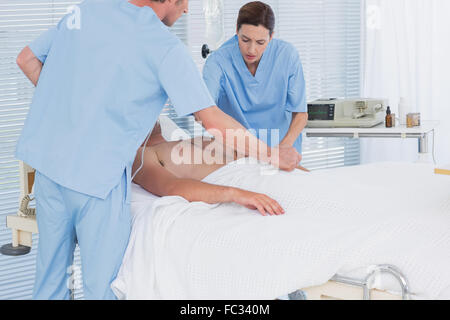 L'équipe médicale de ressusciter un homme avec un défibrillateur Banque D'Images