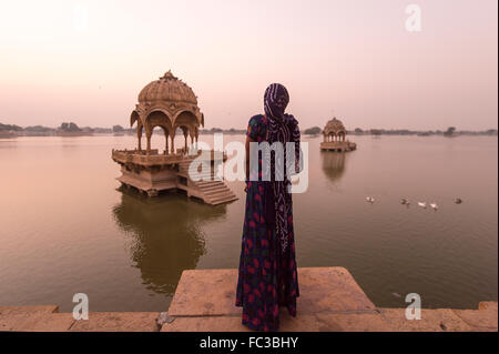 Les femmes non identifiées dans le repère permanent indien le Gadi Sagar temple sur Gadisar lake pendant le lever du soleil. Le lac situé à Banque D'Images