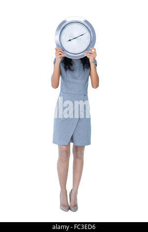 Businesswoman holding grosse horloge en face de son visage Banque D'Images