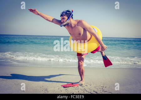 Homme portant des palmes et des anneaux en caoutchouc à la plage Banque D'Images