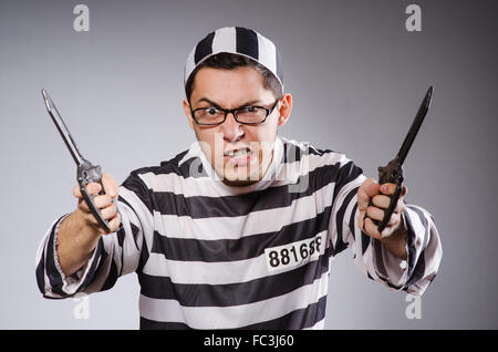 Funny prisonnier avec knuckles isolé sur gray Banque D'Images