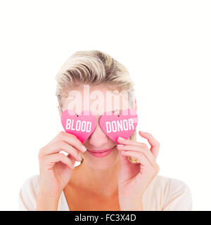 Image composite de young blonde holding cœurs au-dessus des yeux Banque D'Images