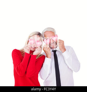 Image composite de silly couple holding cœurs sur les yeux Banque D'Images