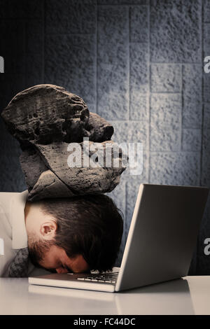 Image composite de l'épuisé businessman sleeping head on laptop Banque D'Images