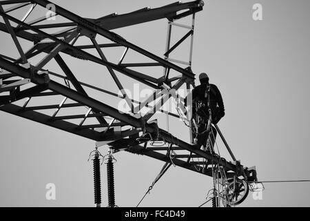 L'assembleur sur un pylône d'électricité Banque D'Images