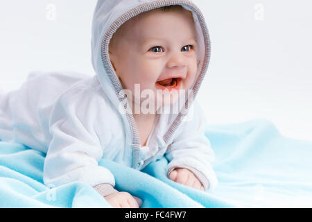 Bébé dans le capot sur une couverture bleue Banque D'Images