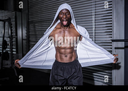 Bodybuilder jeunes dans un hoodie regardant la caméra totalement surpris Banque D'Images