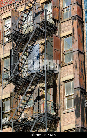 Un escalier de secours sur un vieux bâtiment de brique avec ses volets métalliques rouillées sur Bleeker Street à Soho, Manhattan, New York City Banque D'Images