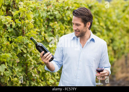 Jeune homme heureux à la bouteille de vin à Banque D'Images