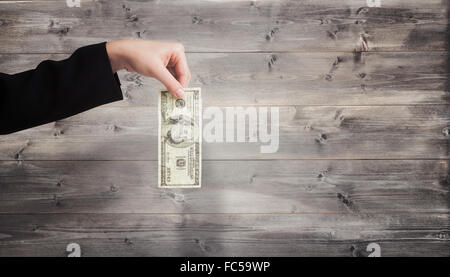 Image composite de businesswomans hand holding hundred dollar bill Banque D'Images