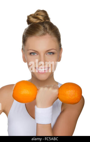 Jeune femme avec deux haltères oranges mûres Banque D'Images