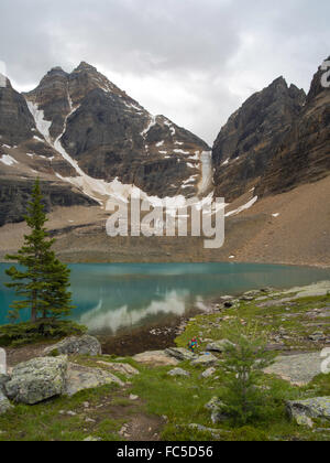 Une fille grimpe sur les rochers, en descendant vers le lac Oesa avec Glacier Glacier Peak et Lac-oesa (à droite) dans l'arrière-plan, dans le parc national Yoho n Banque D'Images