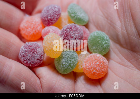 Une portion (13) les sucreries de jelly-tots tenu dans la paume de la main. Banque D'Images