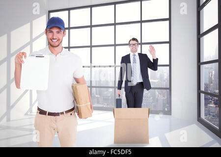 Composite image of delivery man Holding boîte en carton et presse-papiers Banque D'Images