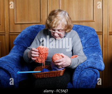 La vieille femme est assise dans un fauteuil Banque D'Images