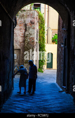 Vieux couple marchant à travers une arcade à Lucca, Italie. Banque D'Images