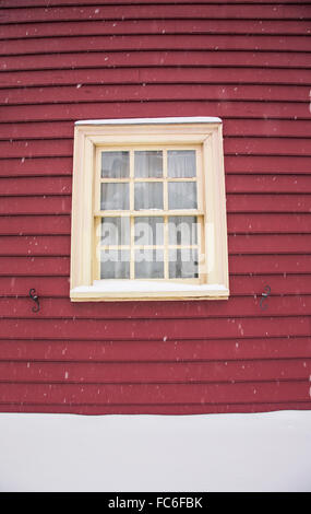 Gros plan vintage maison coloniale rouge gros plan cadre de fenêtre en bois extérieur dans la neige tombant tempête, Monmouth County, New Jersey, États-Unis, scène d'hiver US Banque D'Images