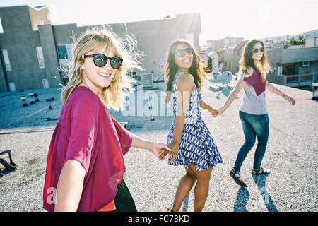 Women holding hands on urban rooftop
