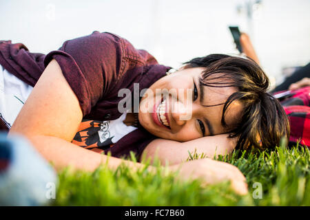 Smiling woman laying in grass Banque D'Images