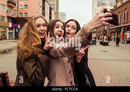 Les femmes de race blanche en tenant l'extérieur selfies Banque D'Images