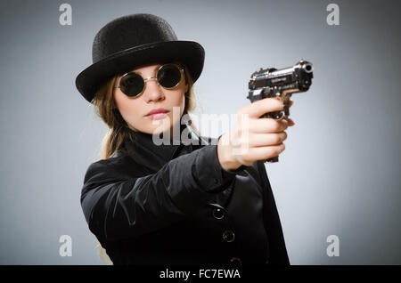 Espion femelle avec arme contre gray Banque D'Images