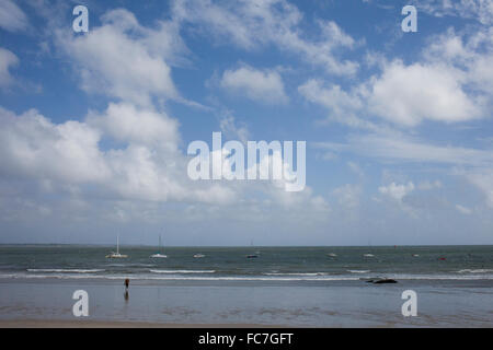 Debout dans les vagues touristiques on beach Banque D'Images