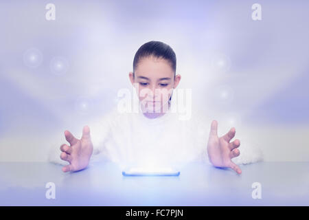 Mixed Race girl With glowing digital tablet Banque D'Images