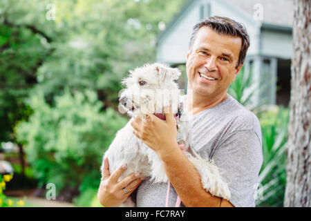 Caucasian man petting dog outdoors Banque D'Images