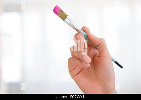 Hispanic woman holding paintbrush Banque D'Images