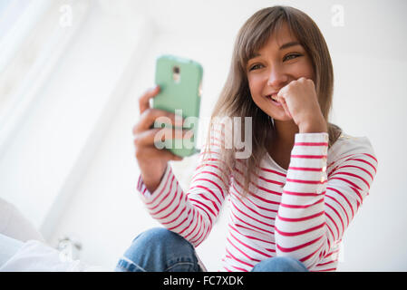 Mixed Race woman with cell phone selfies Banque D'Images