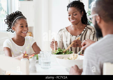 Black family eating salad at table Banque D'Images