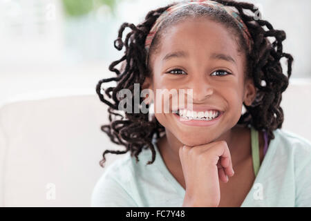 Smiling Black girl resting chin in hand Banque D'Images