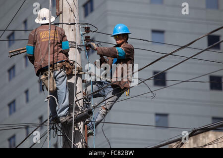 La ville de Cebu, Philippines,Société d'électricité employés travaillant sur des lignes électriques aériennes. Banque D'Images